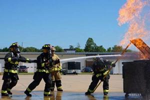 Fire fighters putting out a dumpster fire.
