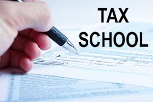 Hand filling out tax form for tax school