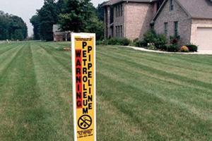 Pipepine warning post in a yard.