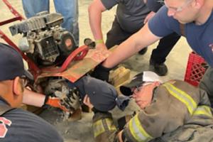 Firefighters practicing extraction from a tiller.
