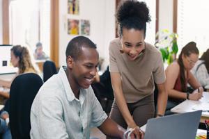Two people sitting looking at a computer