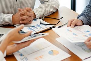 A group sitting around a table looking at data sheets.