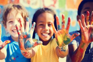 Three kids with paint on their hands from finger painting.
