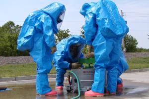 three workers in blue hazmat suits