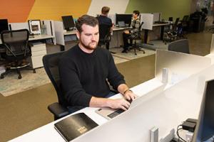 Man typing on a laptop in a computer lab