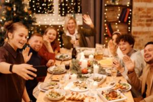 A group of people taking a selfie at a holiday dinner table.