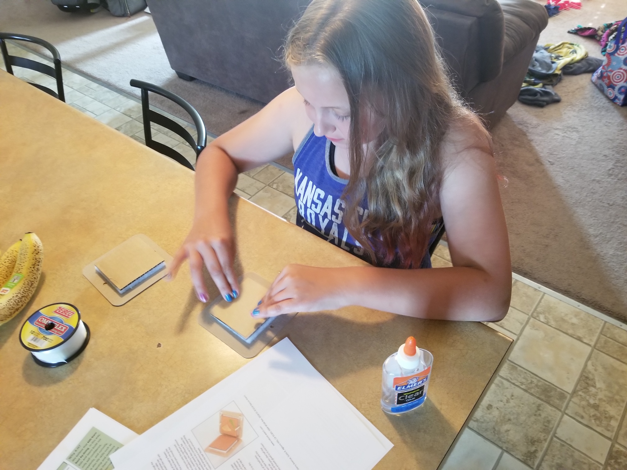 Gracie, 9, of Chariton County, gluing together her leaf and flower press before heading outside to gather items from nature.