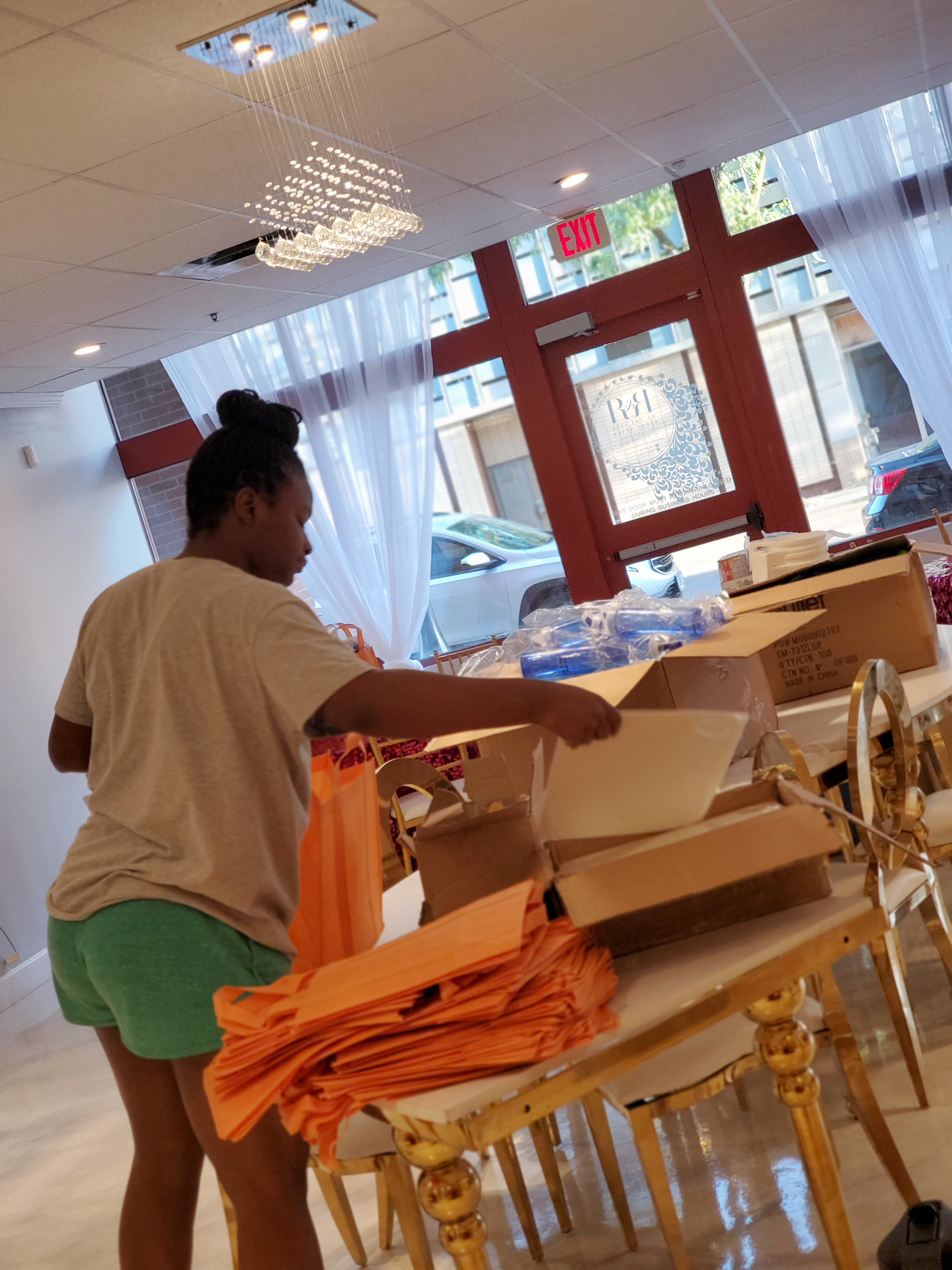 4-H SNAC member Sanai Kintchen readies boxes for 54 healthy recipe ingredient and utensil kits.