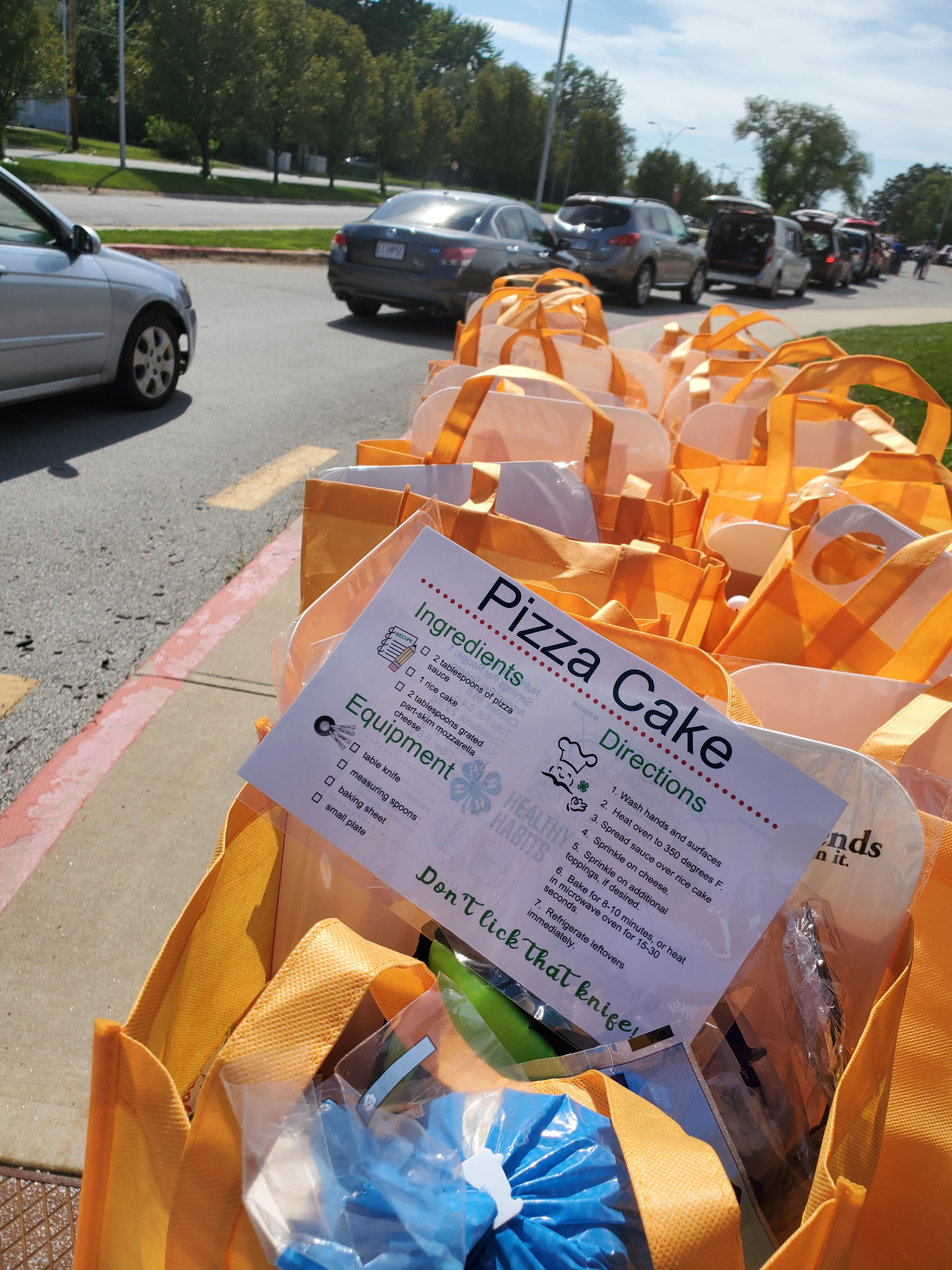 Cars line up for the Pizza Cake healthy recipe kit distribution at the Ruskin High School mobile food pantry in Kansas City.