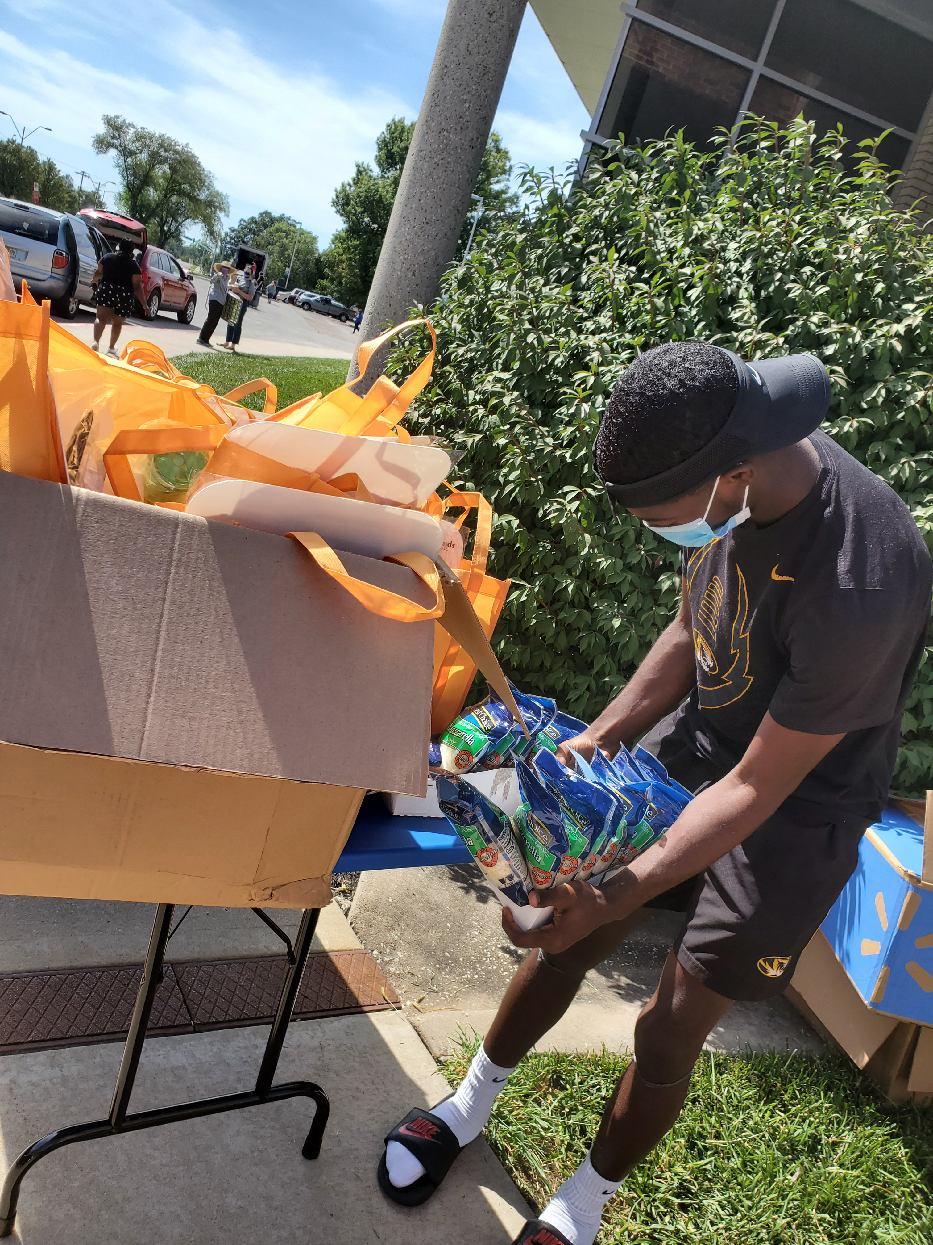 4-H SNAC member Jeremy Jones puts finishing touches on Pizza Cake recipe ingredient and utensil kits before the mobile food pantry distribution.