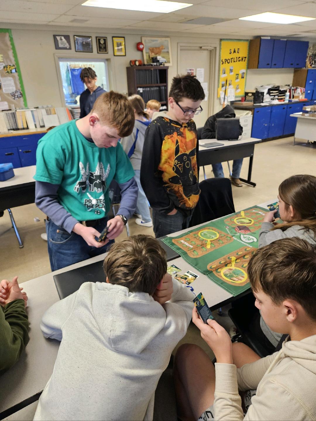 Teen leader Lucas, left, facilitates the Protect the Plate activity with 4-H youths at a club meeting.