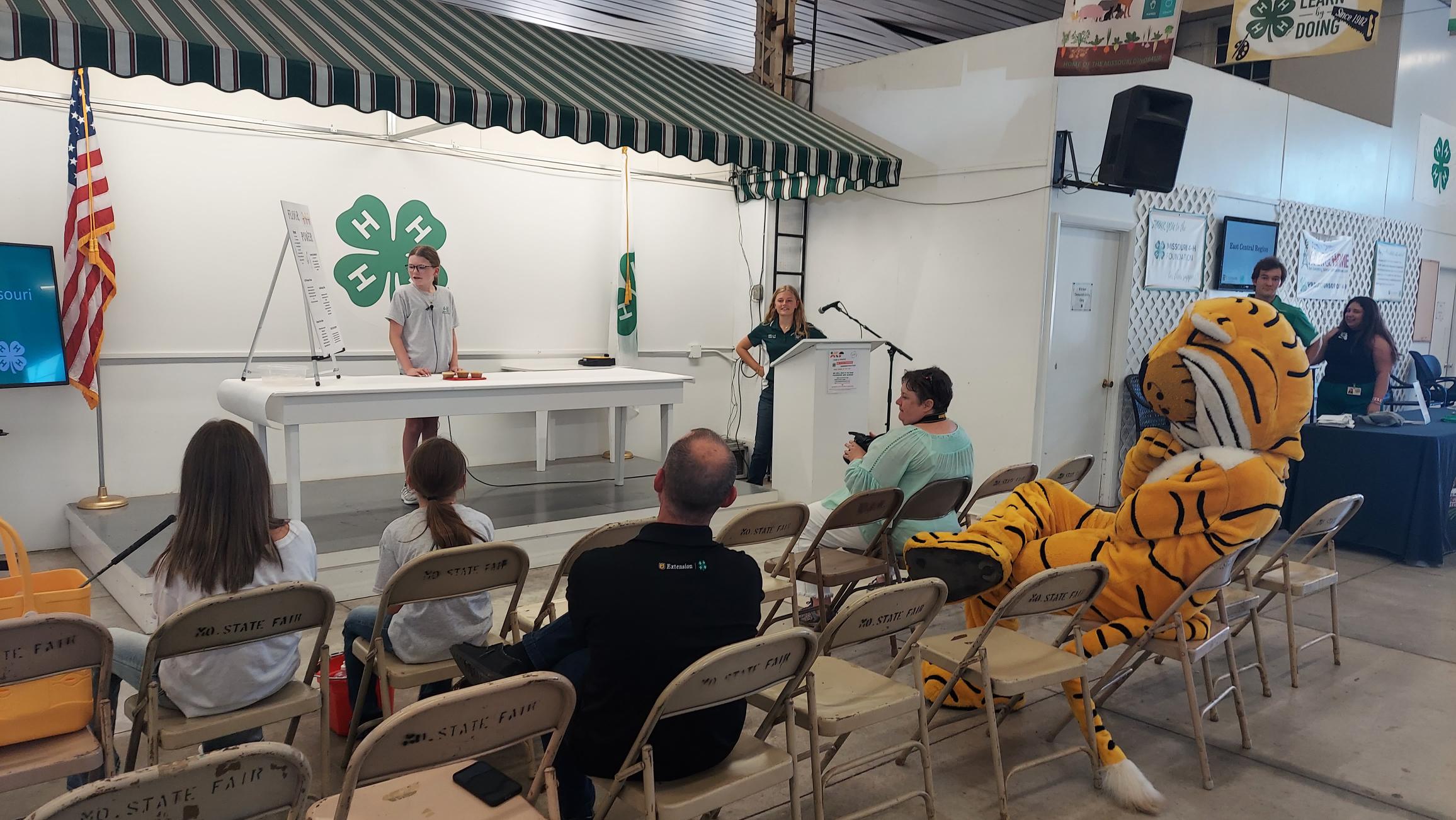 Truman the Tiger watches as Lincoln County 4-H member Jadyn Harris gives a demonstration on “Flour Power.”