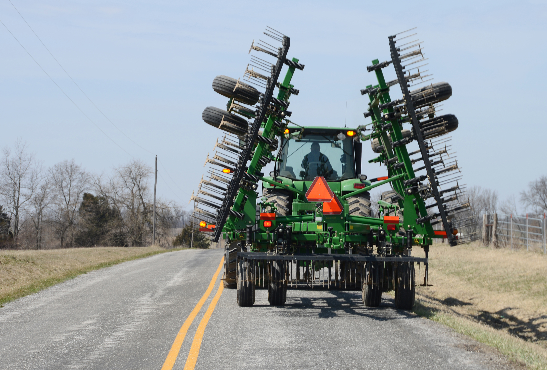 Kent Blades drives a tractor on a road near his Monroe County farm. Safety lights and reflective slow-moving vehicle emblems make it more visible to other motorists, especially from a distance and in low-light conditions. Emily Kaiser, MU Extension