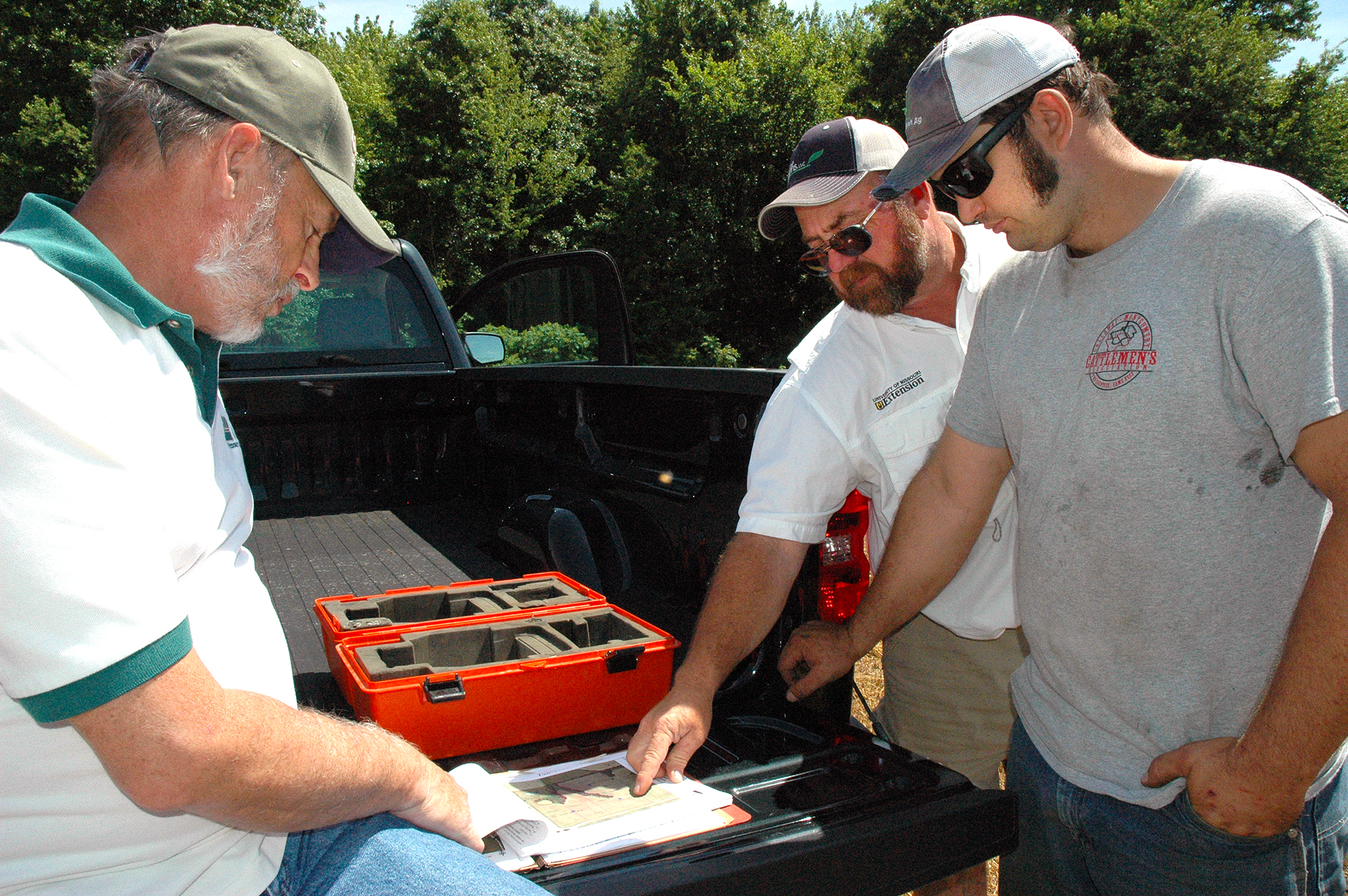 NRCS resource conservationist David Korman, left, and MU Extension agronomist Rusty Lee, center, work with Matthew Spiers, right, to convert cropland to pastureland on Spiers’ Wellsville farm. Photo by Linda Geist