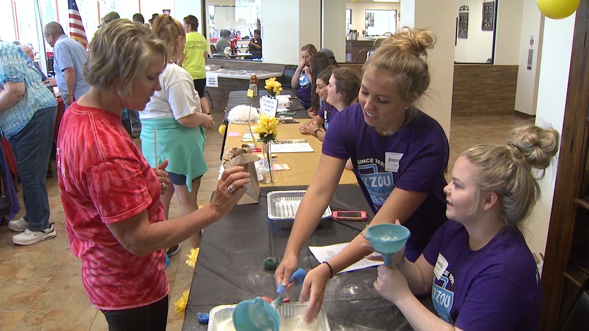 MU students Breanna Evert, center, and Emily Ostert, right, present information on stress management at a health fair in Owensville, Mo.University of Missouri Extension