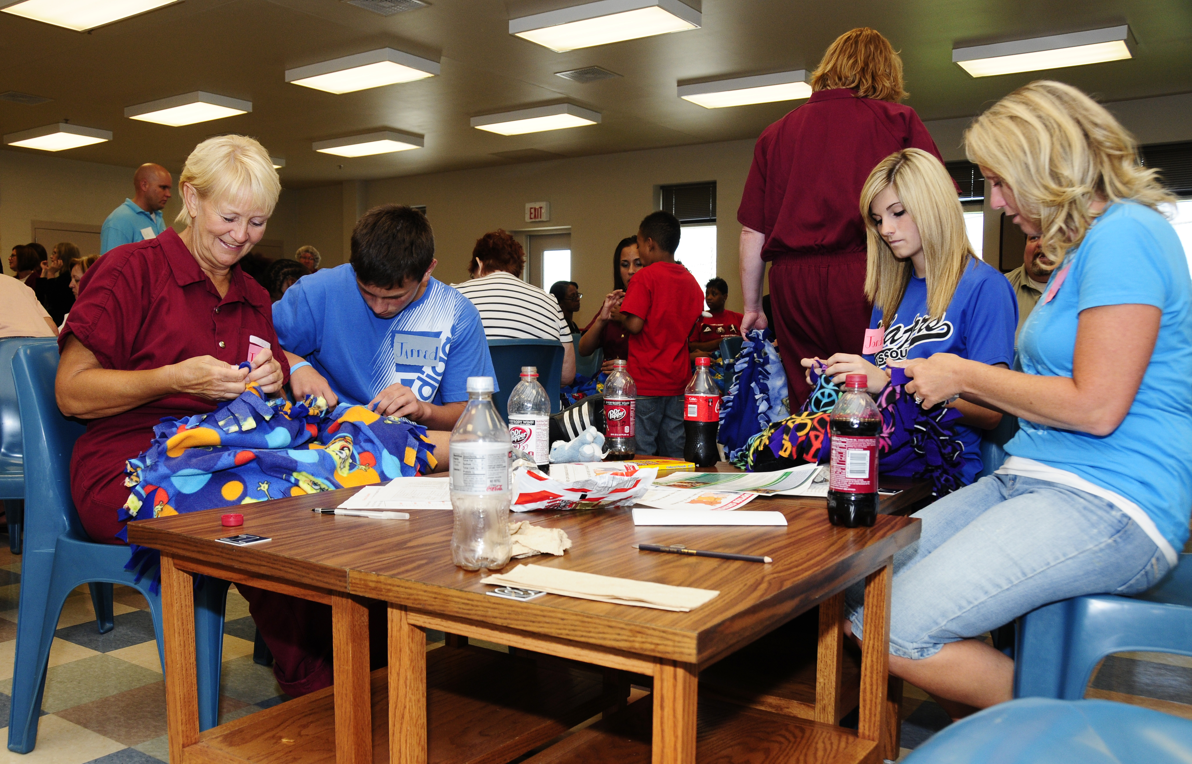 (Left to right) Inmate Judy Henderson makes blankets for the Puppies for Parole project with her grandson, Jarred, her granddaughter, Jordan, and her daughter, Angel, during a 4-H LIFE visit at the Chillicothe Correctional Center. Service projects like thRoger Meissen/MU Cooperative Media Group